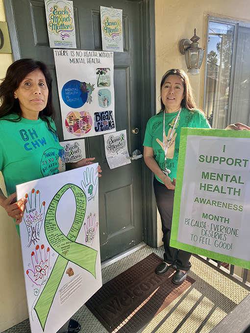 Lucia and Rosie with signs in front of door