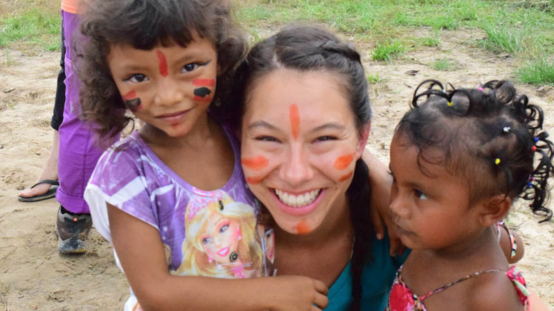 Student with children with paint on faces