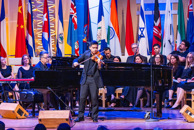 man playing violin with piano and singers